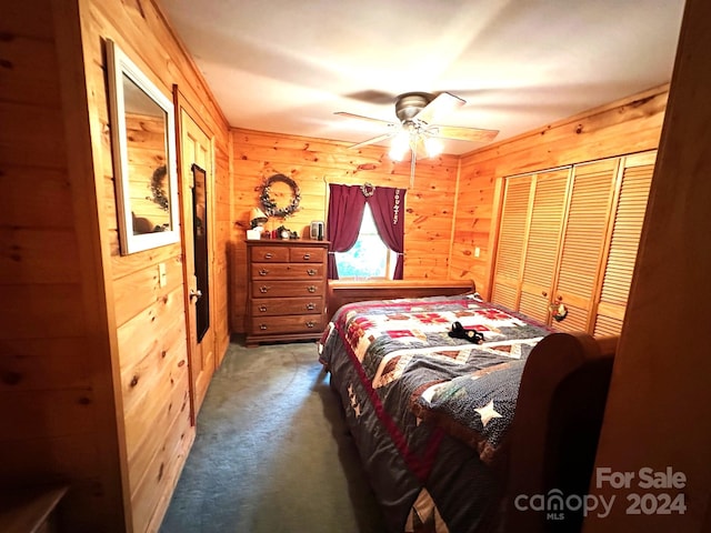 bedroom with ceiling fan, a closet, carpet floors, and wooden walls