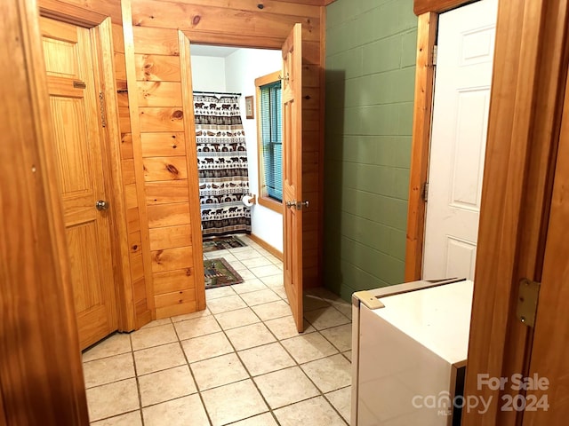 bathroom with tile patterned flooring and wooden walls