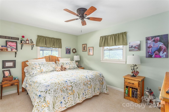 carpeted bedroom featuring multiple windows and ceiling fan