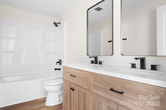 full bathroom with wood-type flooring, toilet, shower / tub combination, and vanity