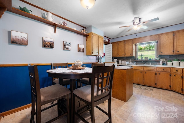 kitchen featuring a textured ceiling, ceiling fan, sink, and tasteful backsplash