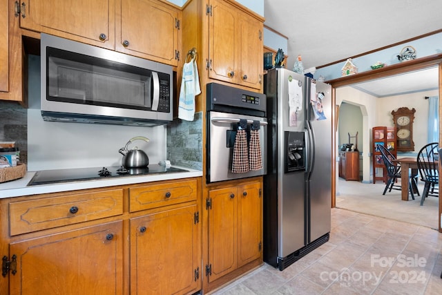 kitchen featuring light colored carpet, stainless steel appliances, and decorative backsplash