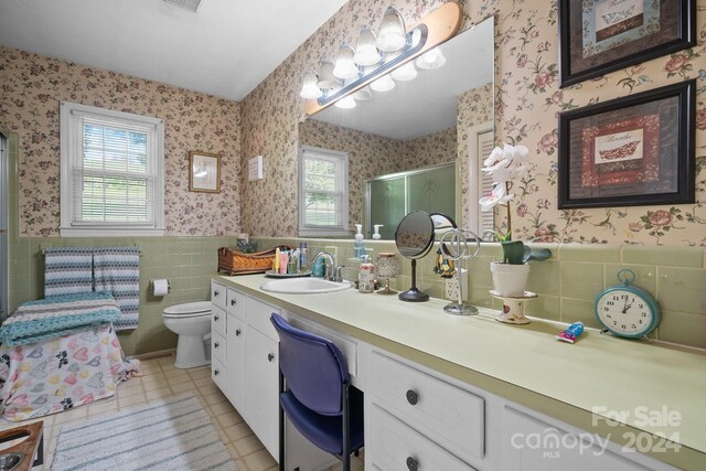 bathroom featuring tile walls, toilet, a wealth of natural light, and vanity