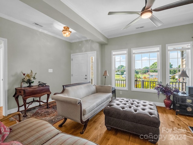 living room featuring wood-type flooring, ornamental molding, and ceiling fan