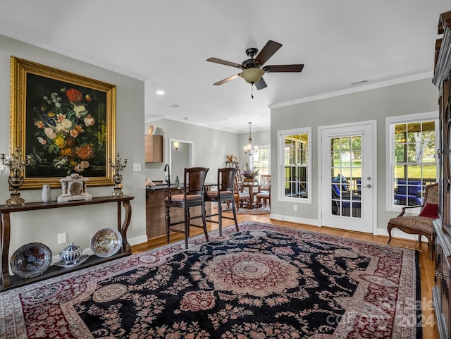 living area featuring ornamental molding, hardwood / wood-style floors, and ceiling fan