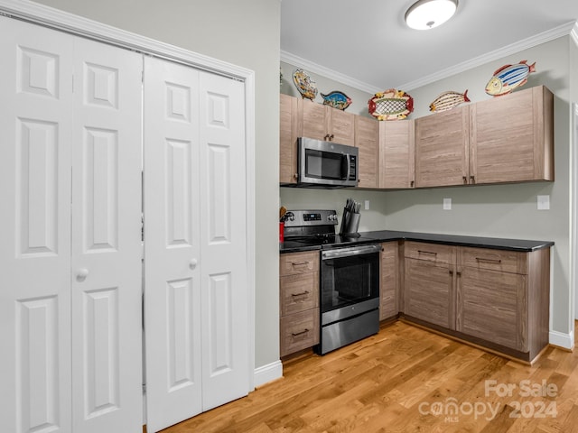 kitchen with ornamental molding, light hardwood / wood-style flooring, and stainless steel appliances