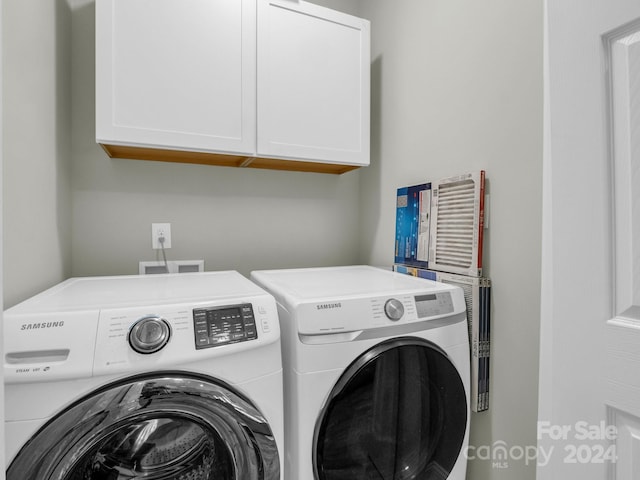 laundry room featuring cabinets and washer and dryer