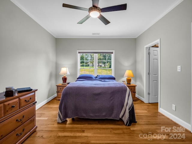 bedroom featuring ceiling fan, crown molding, and wood-type flooring