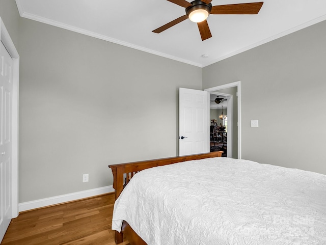 bedroom with crown molding, ceiling fan, and hardwood / wood-style floors