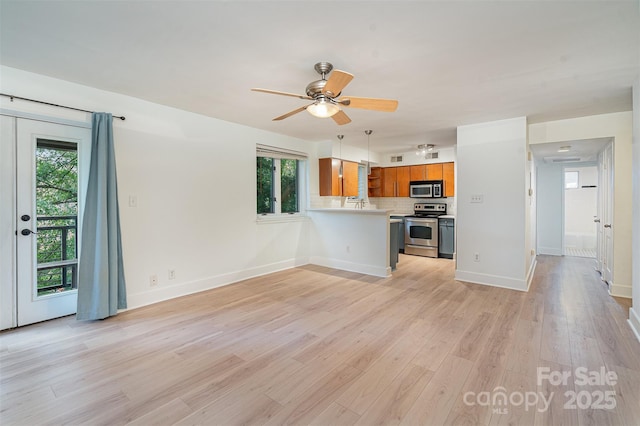 unfurnished living room with ceiling fan and light hardwood / wood-style flooring