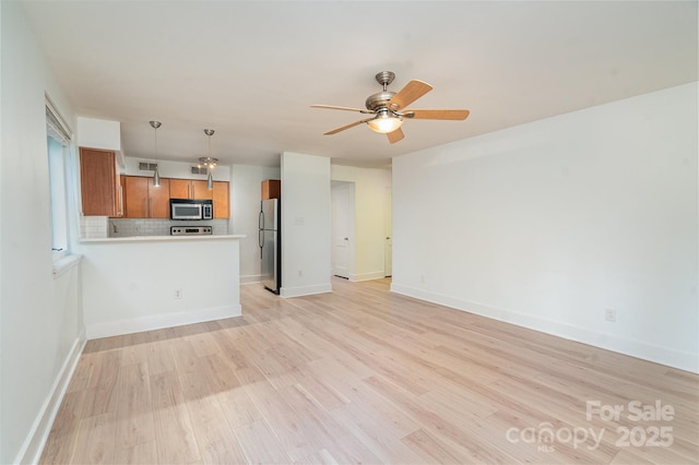 unfurnished living room featuring ceiling fan and light hardwood / wood-style floors