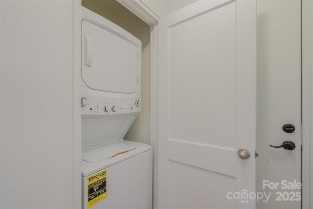 clothes washing area featuring stacked washer / dryer