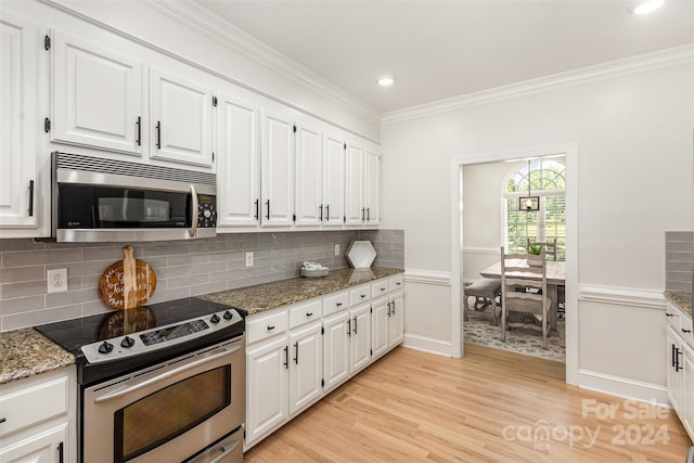 kitchen with light wood finished floors, appliances with stainless steel finishes, white cabinetry, and crown molding