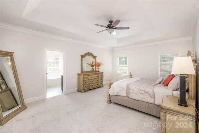 carpeted bedroom with ornamental molding, a tray ceiling, baseboards, and a ceiling fan