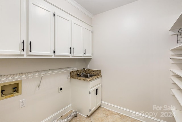 laundry room featuring hookup for a washing machine, cabinet space, hookup for an electric dryer, a sink, and baseboards