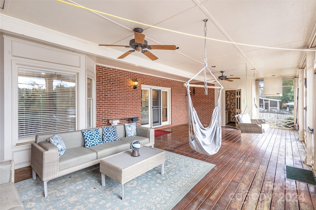 wooden terrace with ceiling fan and an outdoor living space