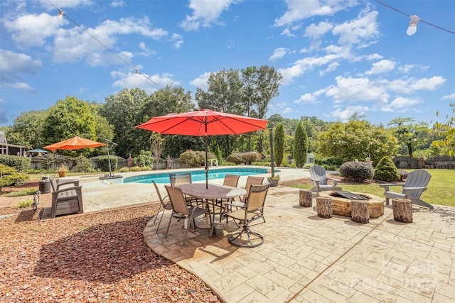 view of patio / terrace featuring an outdoor fire pit, fence, and a fenced in pool