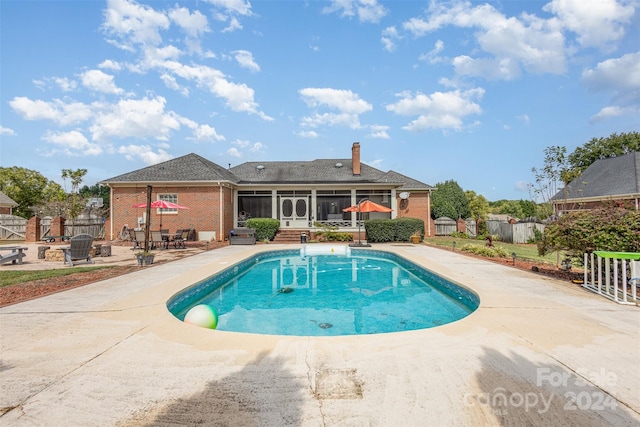 view of pool featuring a fenced in pool, a sunroom, a patio area, and a fenced backyard