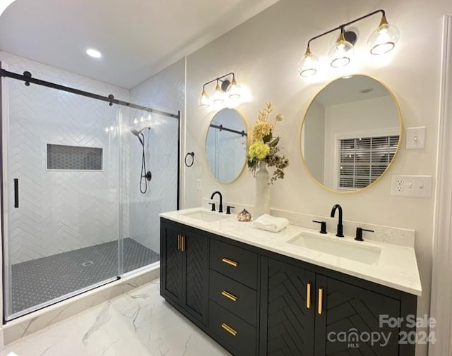 full bath featuring double vanity, marble finish floor, a sink, and a stall shower