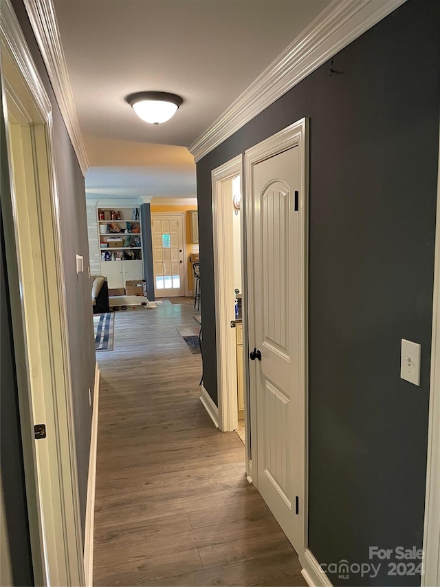 corridor featuring ornamental molding and hardwood / wood-style floors