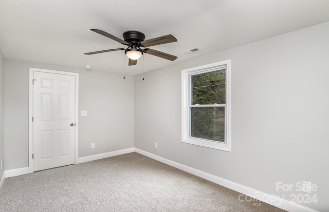 empty room with ceiling fan and carpet flooring