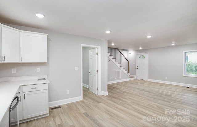 kitchen with white cabinetry, light hardwood / wood-style flooring, and dishwasher