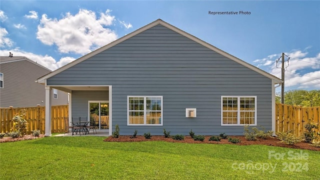 rear view of property featuring a yard and a patio area