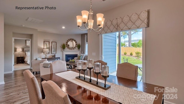 dining room with hardwood / wood-style floors and an inviting chandelier