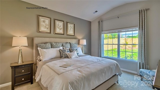 bedroom with lofted ceiling and light colored carpet