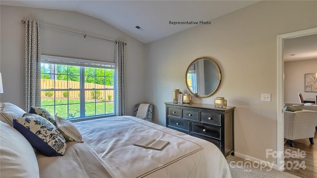 bedroom featuring lofted ceiling and hardwood / wood-style floors