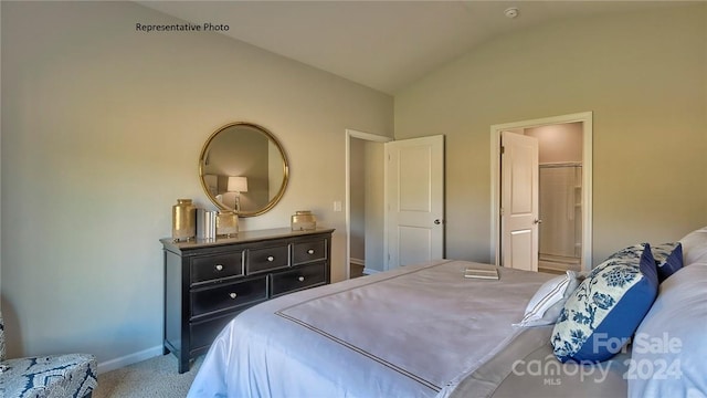 carpeted bedroom featuring lofted ceiling and connected bathroom