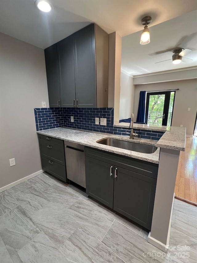 kitchen with sink, light stone counters, tasteful backsplash, stainless steel dishwasher, and kitchen peninsula