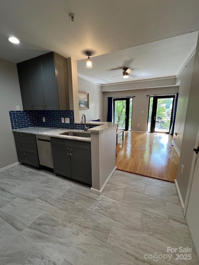 kitchen featuring dishwasher, sink, gray cabinetry, and backsplash