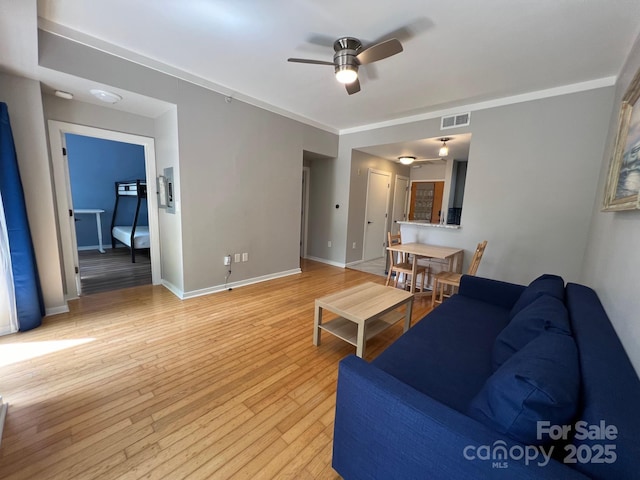 living room with ceiling fan and light hardwood / wood-style flooring