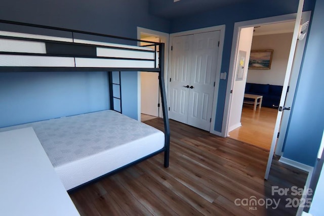 bedroom with dark wood-type flooring and a closet