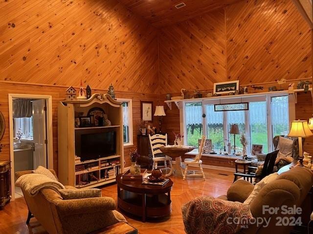 living room with wooden ceiling, high vaulted ceiling, and wood walls