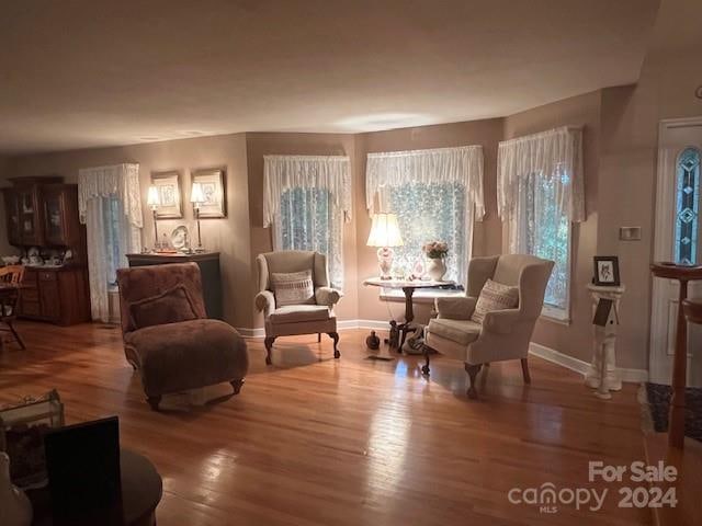 living area with plenty of natural light and hardwood / wood-style floors