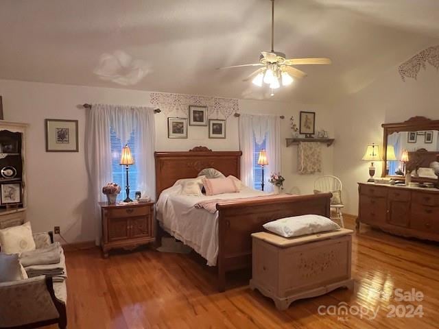 bedroom featuring ceiling fan, light hardwood / wood-style floors, and vaulted ceiling