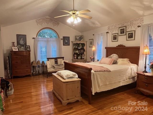 bedroom with ceiling fan, vaulted ceiling, and dark hardwood / wood-style flooring