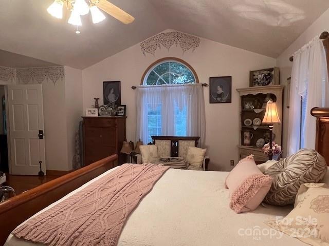 bedroom with lofted ceiling, hardwood / wood-style floors, and ceiling fan