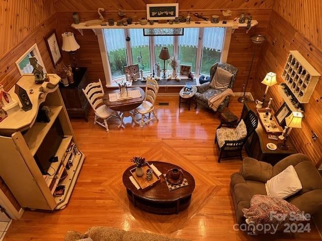 living room featuring wood walls, hardwood / wood-style flooring, and wooden ceiling