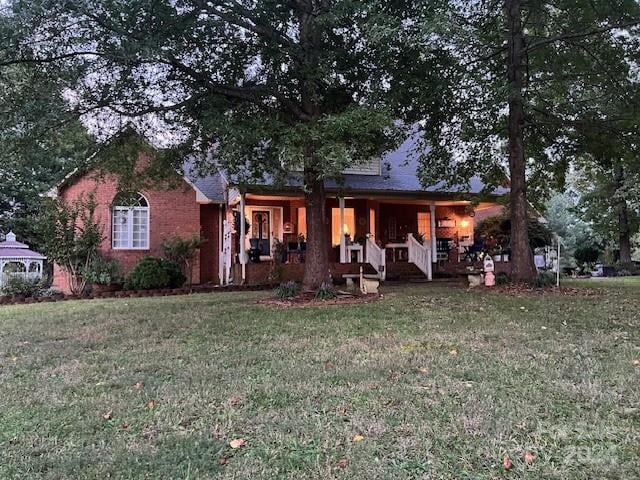 view of front of property featuring covered porch and a front yard