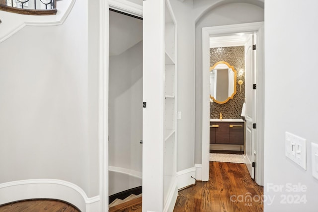 interior space with vanity, hardwood / wood-style flooring, and tasteful backsplash