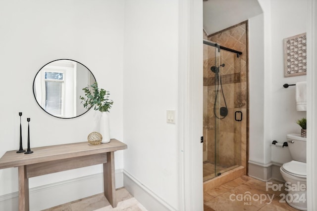 bathroom with toilet, tile patterned flooring, and an enclosed shower