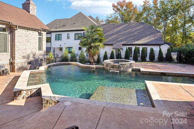 view of pool with an in ground hot tub, pool water feature, and a patio