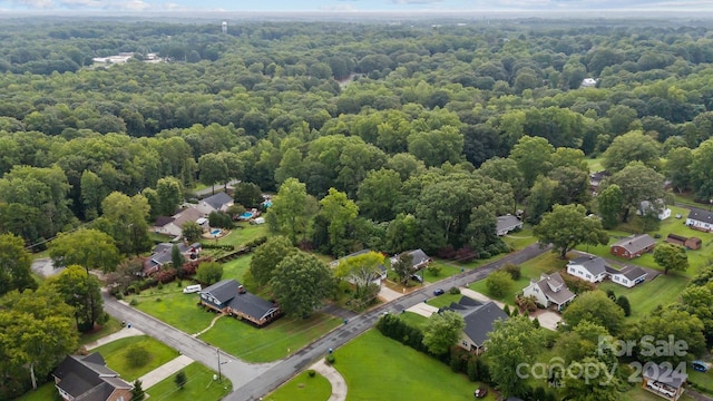 bird's eye view with a wooded view