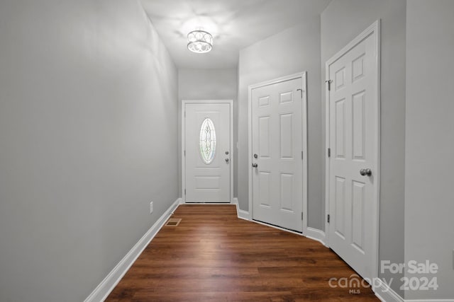 entryway with dark wood-style flooring, visible vents, and baseboards