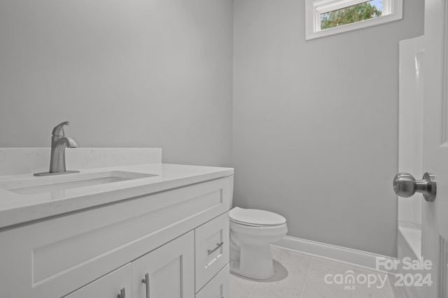 bathroom featuring toilet, baseboards, and vanity