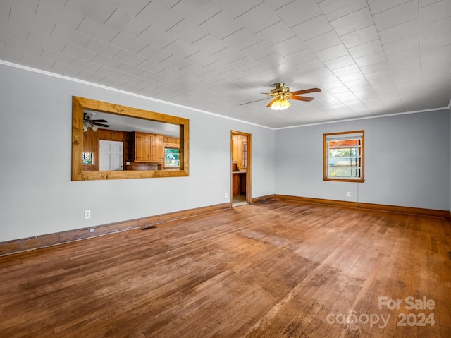 empty room with hardwood / wood-style floors, ceiling fan, and crown molding