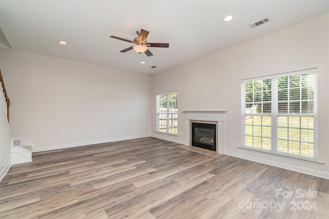 unfurnished living room with ceiling fan and wood-type flooring